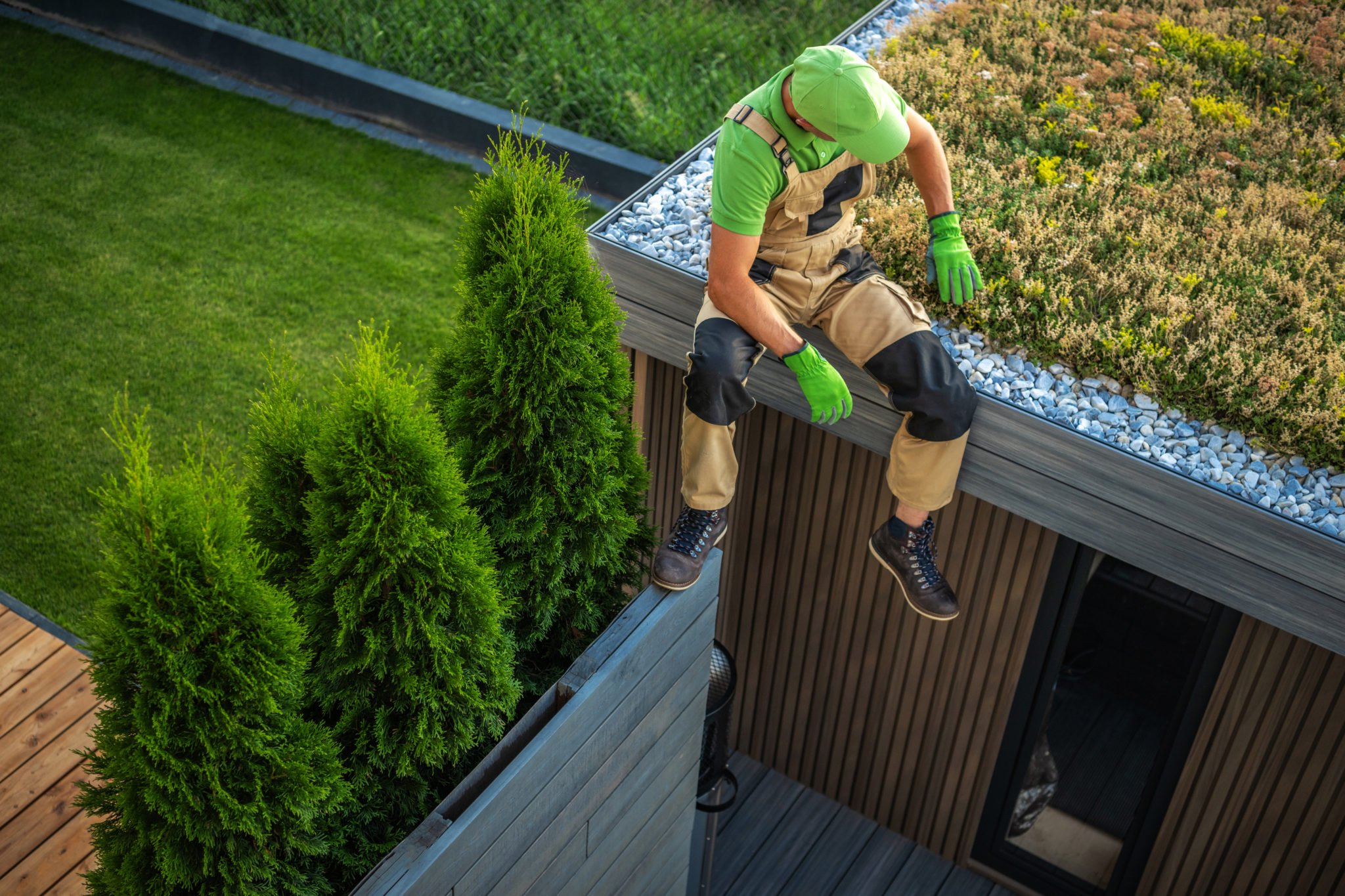 Home With Green Grass and Man on Roof